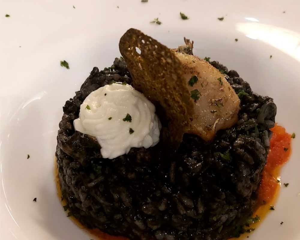Plato de arroz con tinta de calamar elaborado en Restaurante Txalupa